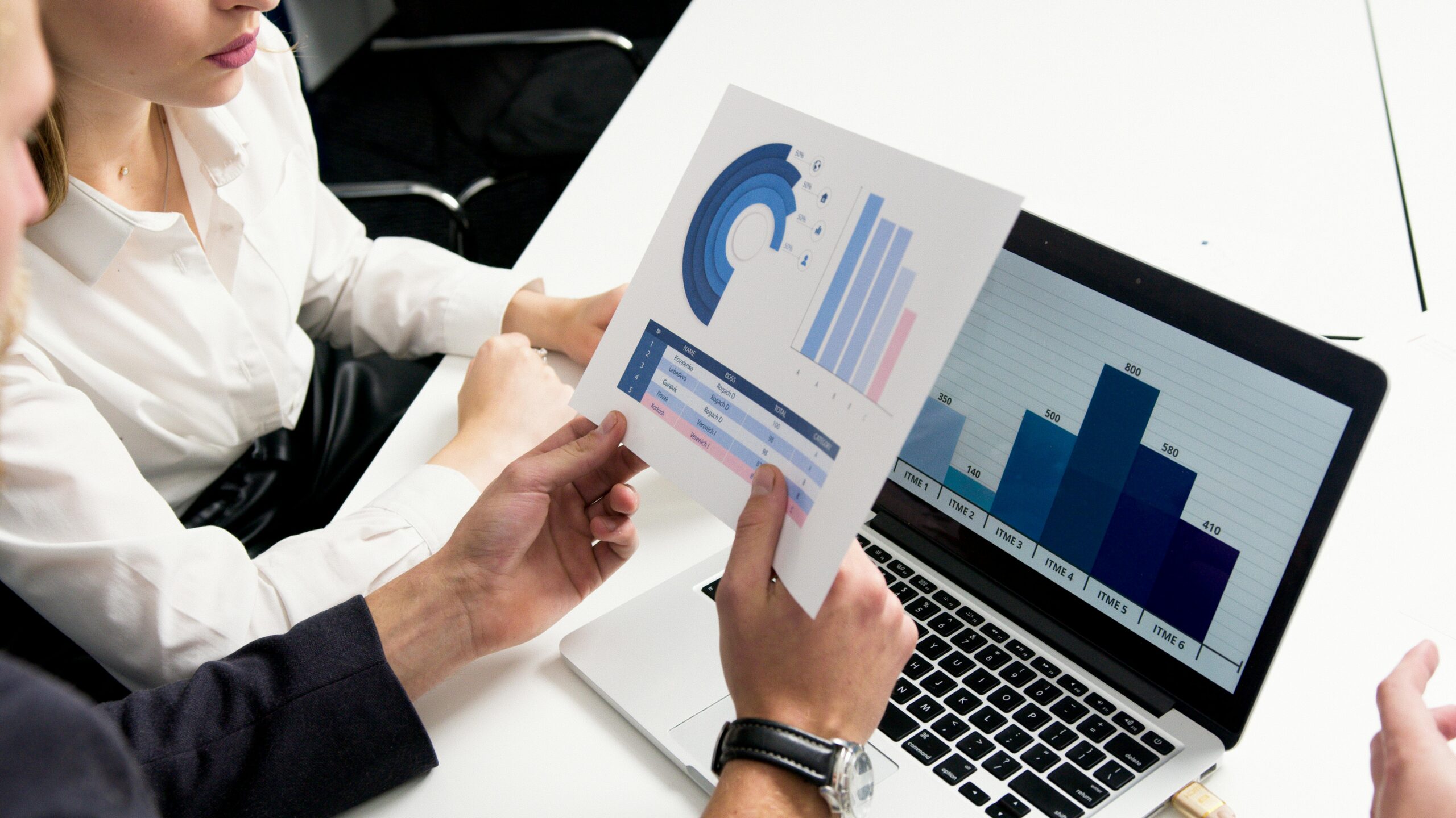 Services Business professionals discussing data charts and graphs in a modern office setting.